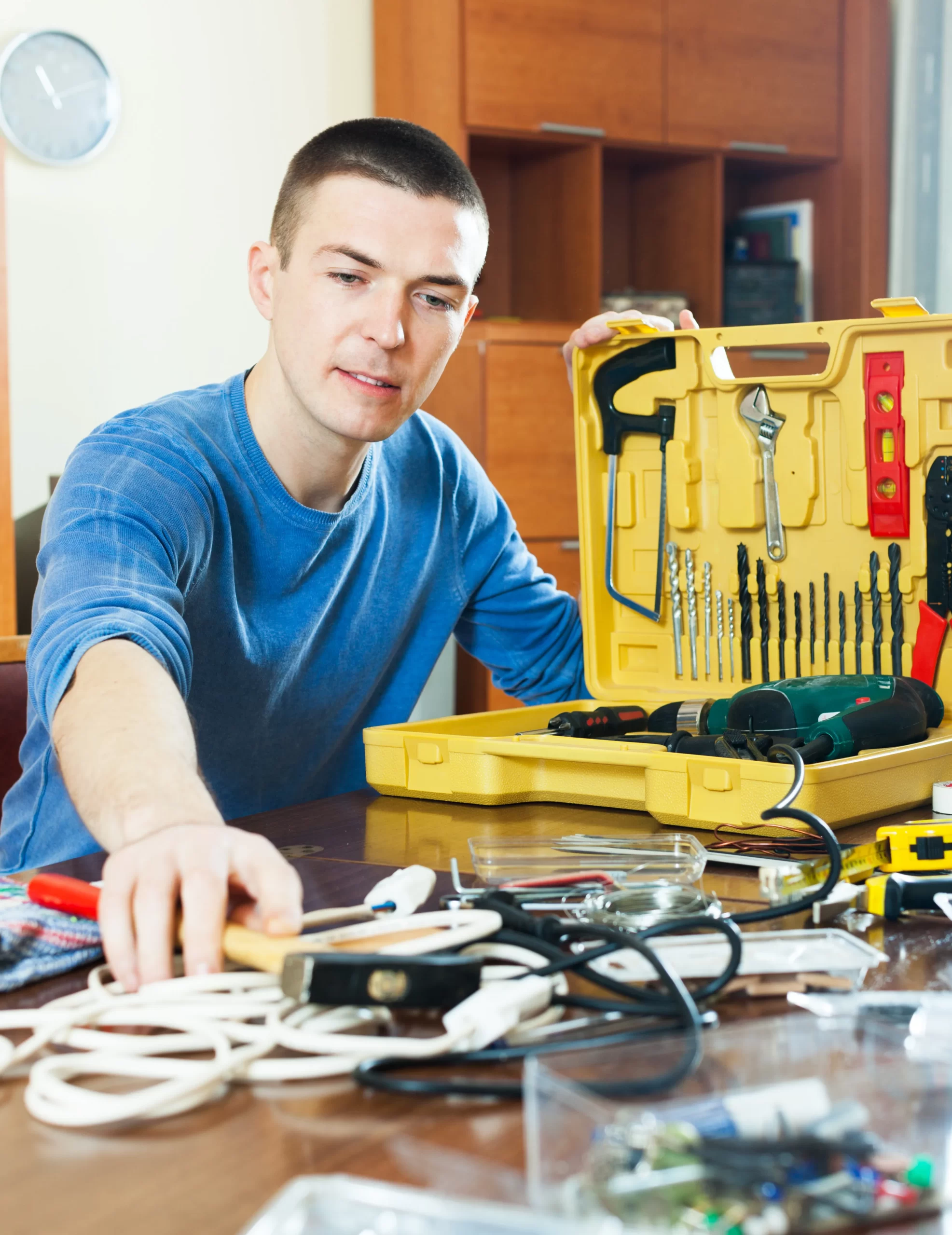 handsome man with toolbox reaching hammer scaled